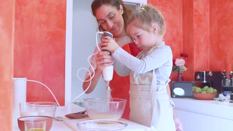 kleine-Mädchen-und-Mutter-Schlagsahne-Eier-mit-elektrischen-mixer