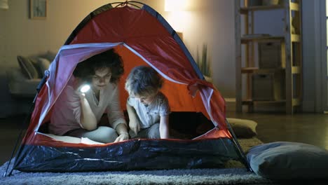 Mother-and-Son-Reading-Book-in-Tent