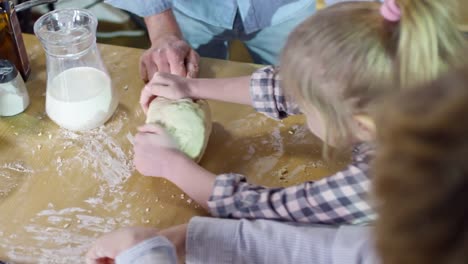 Little-Girl-Kneading-Dough-on-Worktop