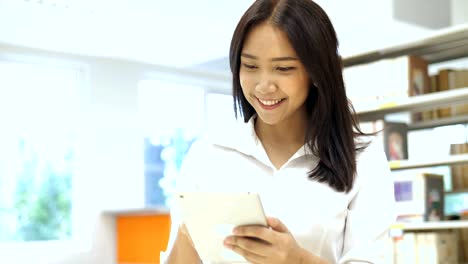 4K-Slow-motion-:-Happy-Beautiful-Asian-student-girl-using-digital-tablet-in-library