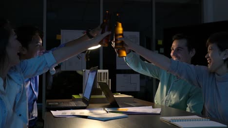 Team-Mitarbeiter-trinken-gerne-für-Success-Projekt-nach-harter-Arbeit-bis-spät-in-die-Nacht-im-Büro.-Geschäftsleute-Überstunden.-Konzept-der-Tagungsraum,-Business-entspannen-und-belohnen.