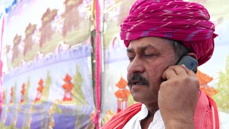 Handheld-Nahaufnahme-eines-Mannes-reden-Ernst-auf-seinem-Handy-in-Rajasthan