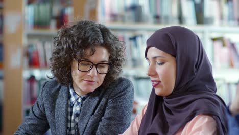 Frau-in-Hijab-arbeiten-mit-Lehrerin-bei-Lektion