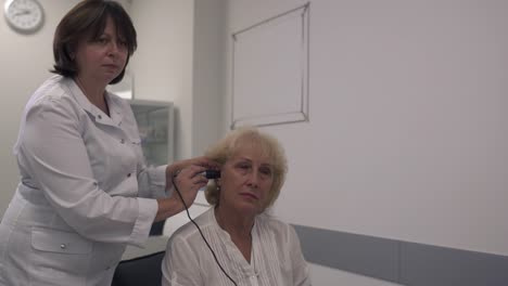 Medical-professional-tests-the-ear-of-an-adult-woman