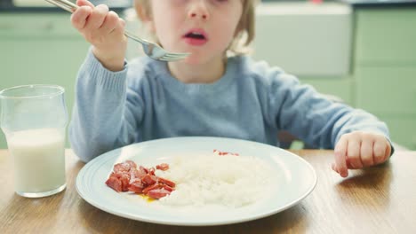 Chico-lindo-comer-Chorizo-con-un-tenedor-en-la-mesa