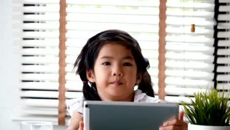 Asian-girl-using-tablet-at-home.-people-with-technology-concept.-4k-resolution