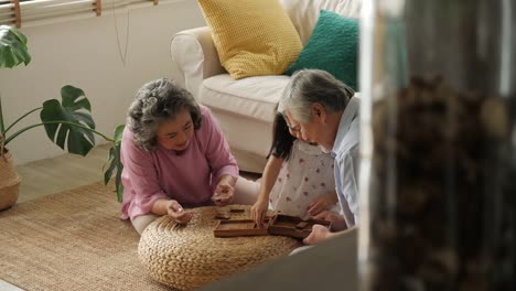 Asiatische-älteres-Paar-spielen-zusammen-mit-einem-kleinen-Mädchen-zu-Hause.-Familie-Senior-Lifestyle-Konzept.