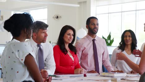 Mujer-jefe-y-equipo-reunión-en-oficina-de-planta-abierta,-de-cerca