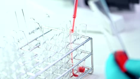 Close-up-of-scientist-dripping-chemical-into-test-tube.-Hands-only,-selective-focus.