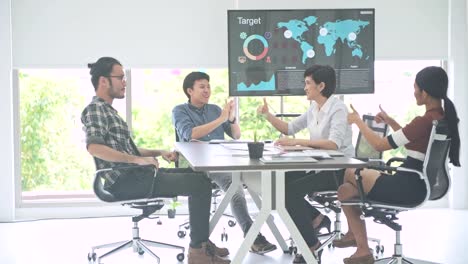 Reunión-de-negocios.-Pequeño-en-marcha-reunión-de-negocios-en-la-habitación.-El-equipo-asiático-con-hombre-y-mujer-acabar-su-trabajo-y-celebrar,-sentarse,-hacia-cámara.-Nuevo-modelo-de-negocio-en-marcha-conceptos.