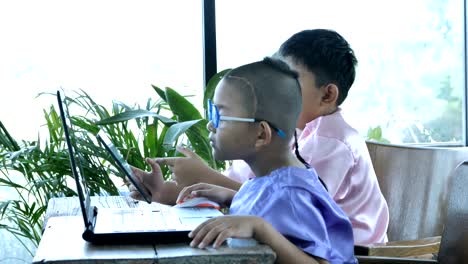 Glückliche-kleine-asiatische-junge-zwei-Menschen-mit-Computer-Laptop.