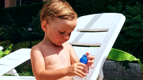 Happy-little-boy-sitting-near-the-pool