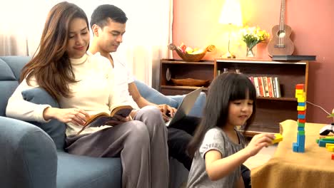 cute-black-hair-child-female-daughter-homework-and-laugh-together-with-parent-in-living-room-house-concept