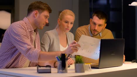 ui-designers-with-laptop-and-app-templates-working-at-night-office