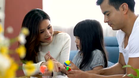 cute-black-hair-child-female-daughter-homework-and-laugh-together-with-parent-in-living-room-house-concept