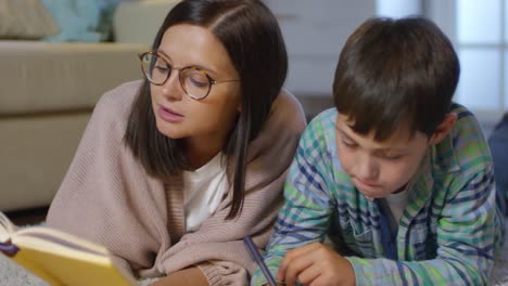 Mom-and-Kid-Doing-Homework-Together-on-Floor-in-Living-Room