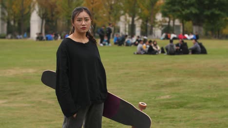 Asiatische-weibliche-College-Student-Portrait-mit-skateboard