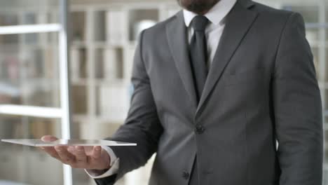 Businessman-Using-Futuristic-Tablet-in-Office