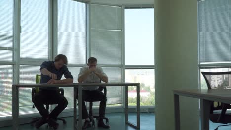 Two-handsome-guys-and-a-girl-work-in-a-beautiful-office