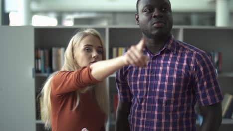 European-woman-and-african-american-choose-a-book-in-the-library