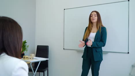 junge-Lehrerin-unterrichtet-Schülerinnen-und-Schüler-im-Klassenzimmer