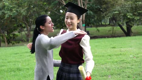 Young-Asian-female-graduate-hugging-her-friend-at-graduation-ceremony.-International-diversity-background