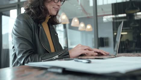 Mujer-de-negocios-ocupada-trabajando-en-ordenador-portátil-en-la-oficina