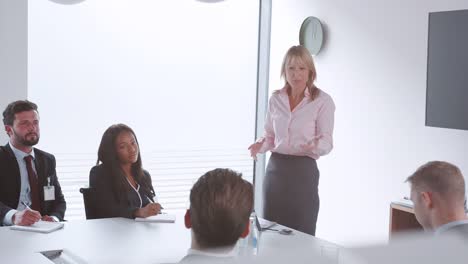 Reife-Geschäftsfrau-Adressierung-Fraktionssitzung-Tisch-am-Graduate-Recruitment-Assessment-Tag