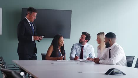 Gruppe-gemeinsam-an-Task-am-Graduate-Recruitment-Assessment-Tag-während-von-reifer-Geschäftsmann-beobachtet