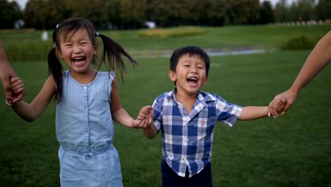 Porträt-des-Lachens-asiatischen-Geschwister-zu-Fuß-im-park