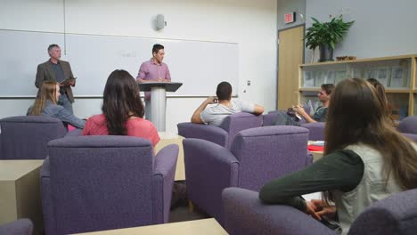 A-student-giving-a-presentation-to-the-class-and-writing-on-the-whiteboard