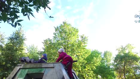 Blonder-Junge-und-Mädchen-in-Gläsern-auf-dem-Spielplatz.-Kinder-klettern-überall-und-lachen.