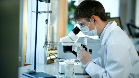 Scientist-looking-through-a-microscope-in-a-laboratory