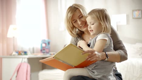 Niedliche-kleine-Mädchen-sitzt-auf-ihrer-Großmutter-Schoß,-und-sie-lesen-Kinder-und-Jugendbuch.-Slow-Motion.