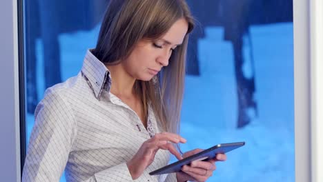 Business-woman-using-tablet-computer-sitting-near-the-window-in-hotel