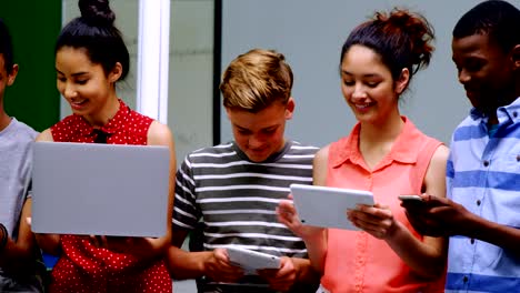 Students-using-laptop,-mobile-phone-and-digital-tablet