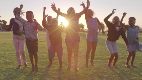 La-escuela-primaria-los-niños-saltando-al-aire-libre-al-atardecer