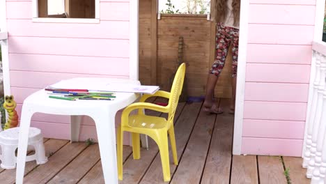 Hinterhof-Spielplatz-Kinderspielhaus.-Kinder-spielen-im-hölzernen-rosa-Spielhaus.