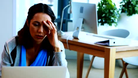 Female-executive-working-over-laptop-in-office