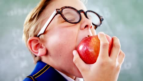 Schoolboy-eating-apple-in-classroom