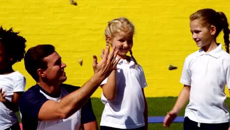 School-kids-giving-high-five-to-coach