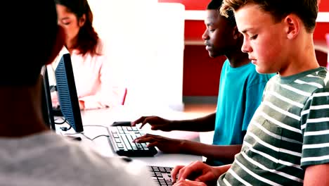 Estudiantes-trabajando-en-la-computadora-en-montaje-tipo-aula