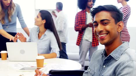 Executive-smiling-while-colleague-discussing-in-background-4k