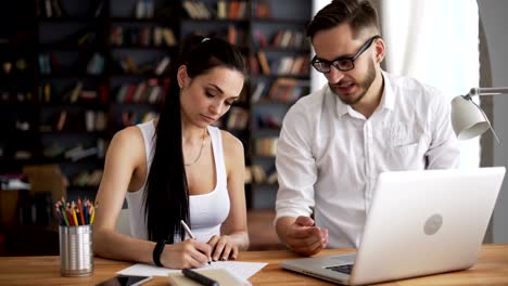 Two-start-up-partners-discuss-and-smile-in-loft