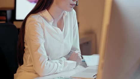 Atractiva-mujer-profesional-con-una-encantadora-sonrisa-radiante-usando-un-auricular-y