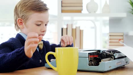 Boy-drinking-coffee-while-working-on-typewriter-4K-4k