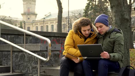 Students-with-laptop-and-tablet-in-park