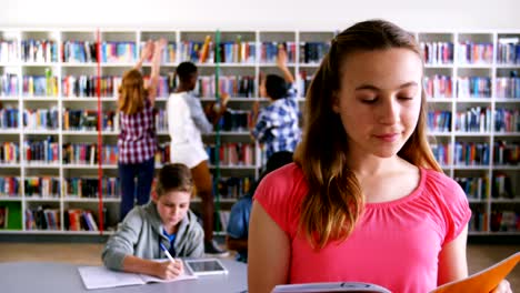 Portrait-of-happy-schoolgirl-reading-book-4k