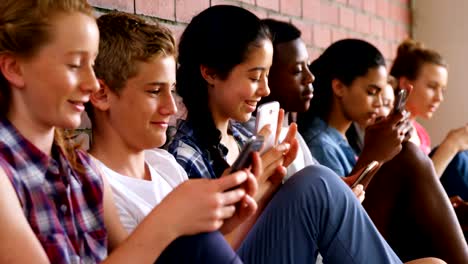 Group-of-school-friends-using-mobile-phone-4k