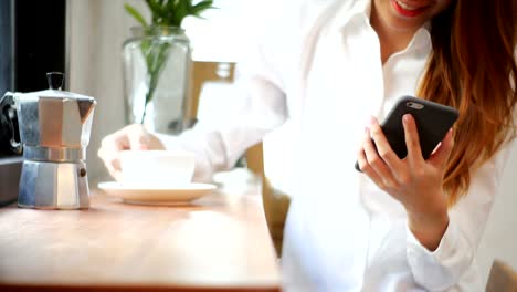 Empresaria-utilizar-teléfono-móvil-y-beber-café-en-mesa-de-madera.-Mujer-asiática-con-teléfono-y-taza-de-café.-Freelance-trabajar-en-cafetería.-Woking-fuera-de-oficina-estilo-de-vida.